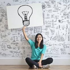 woman draw a light bulb in white board