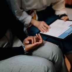 person in white long sleeve shirt holding a clipboard with resume