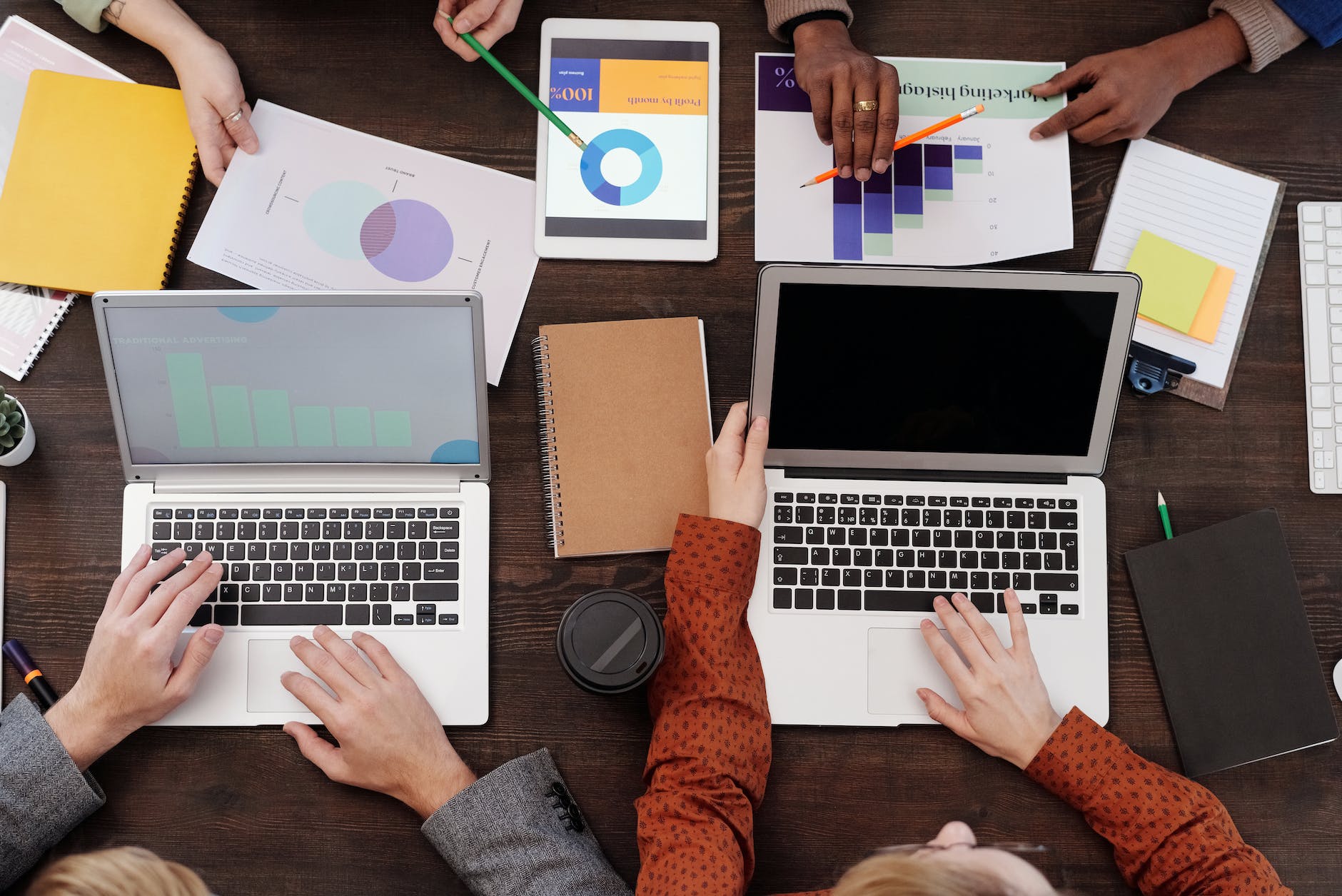 a group of people with graphs and pie charts on table