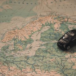 black toy car on world map paper