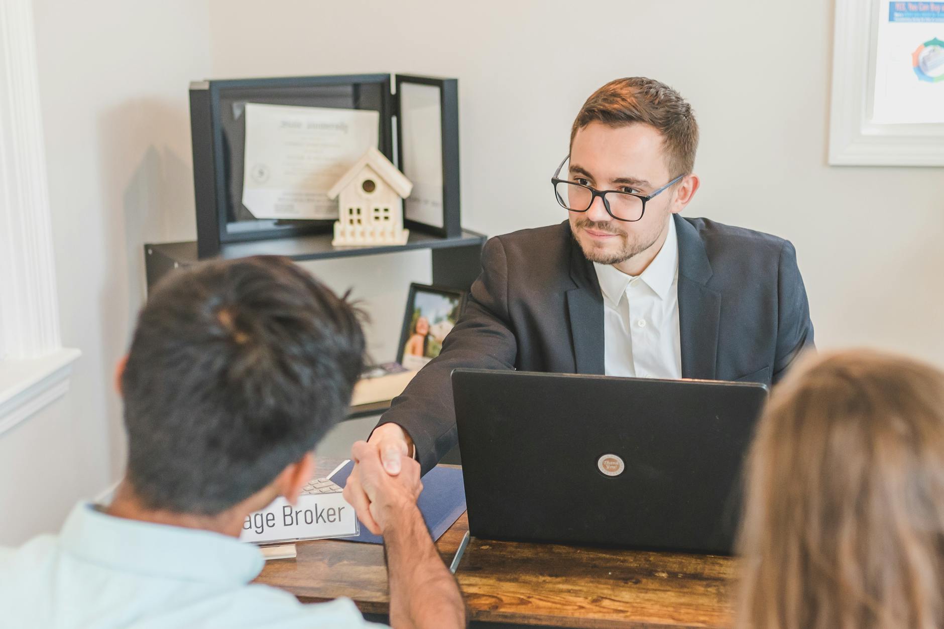 a mortgage broker handshaking with clients