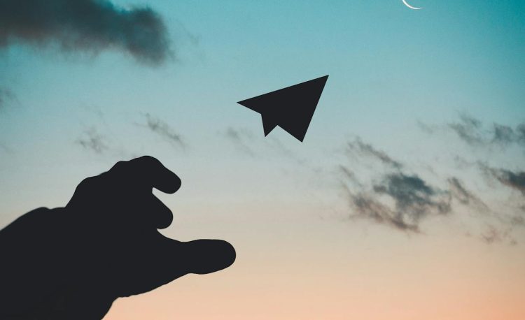 silhouette photo of man throw paper plane