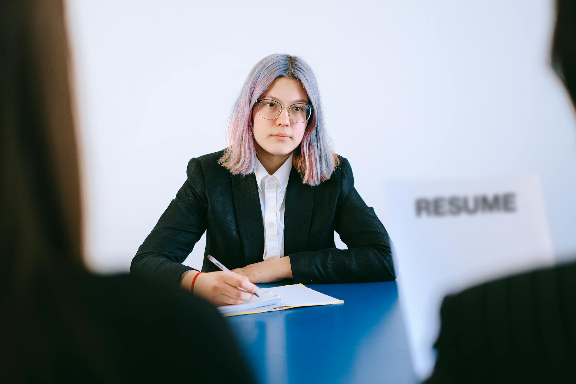 woman sitting by a table taking notes at a meeting