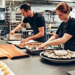 man and woman wearing black and white striped aprons cooking