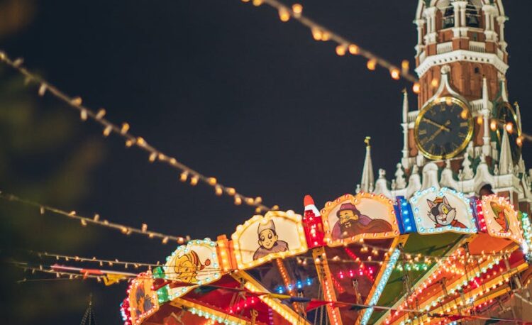 colorful luminous carousel against kremlin on red square at night