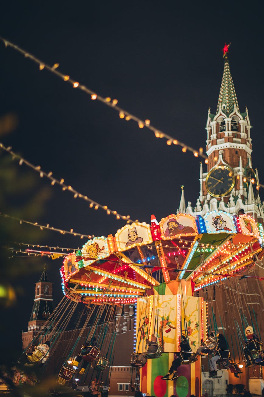 colorful luminous carousel against kremlin on red square at night