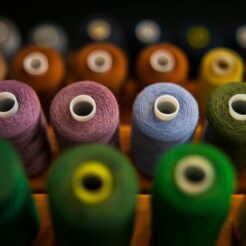 selective focus photography of assorted coloured thread spools