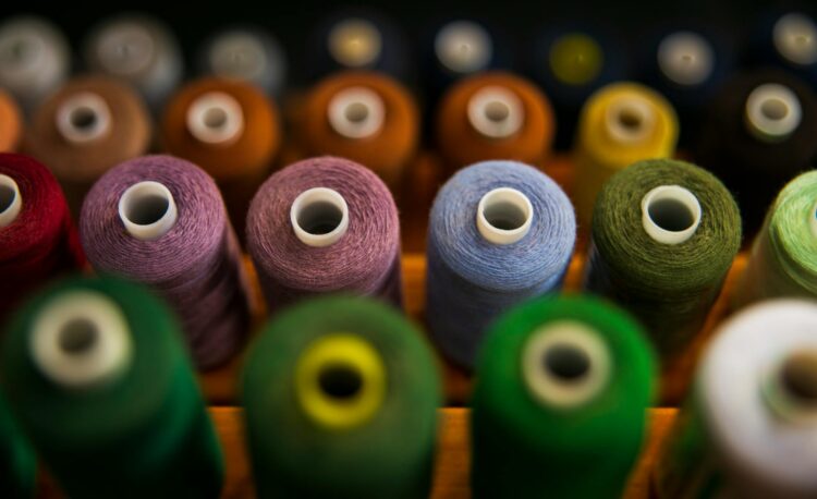 selective focus photography of assorted coloured thread spools