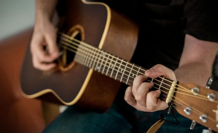 person playing brown guitar