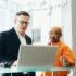 man using silver laptop beside another man