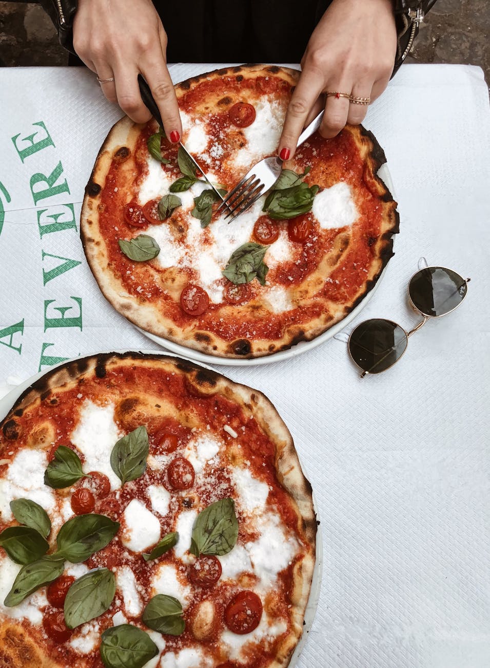 person slicing pizza