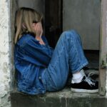 lonely girl sitting on a doorway