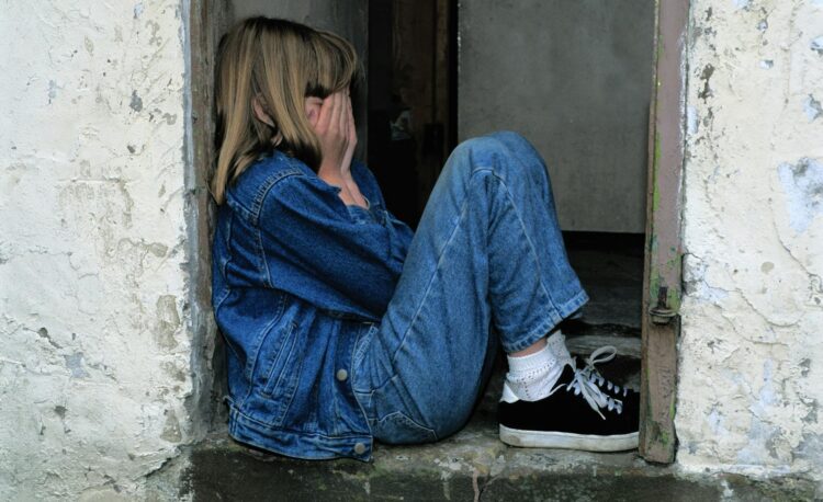 lonely girl sitting on a doorway