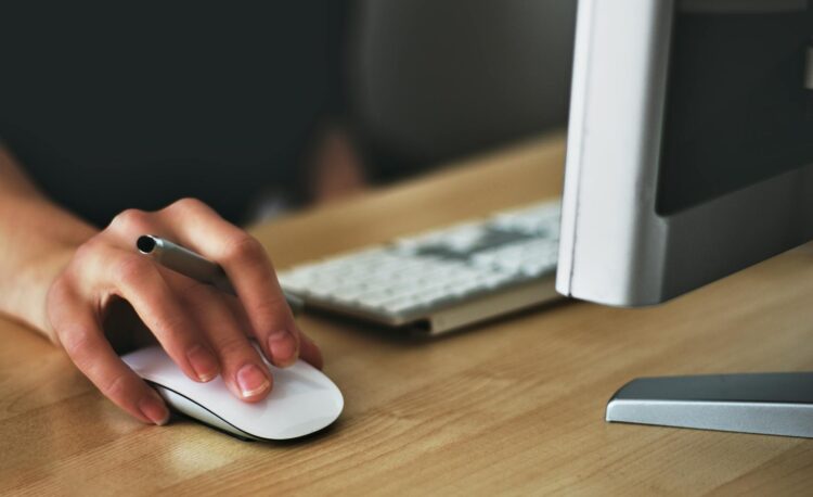 person holding apple magic mouse