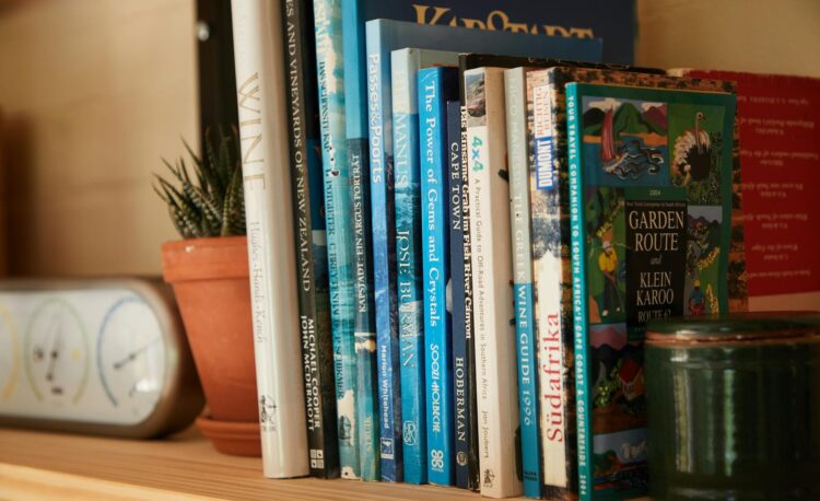 books placed on shelf with potted plants