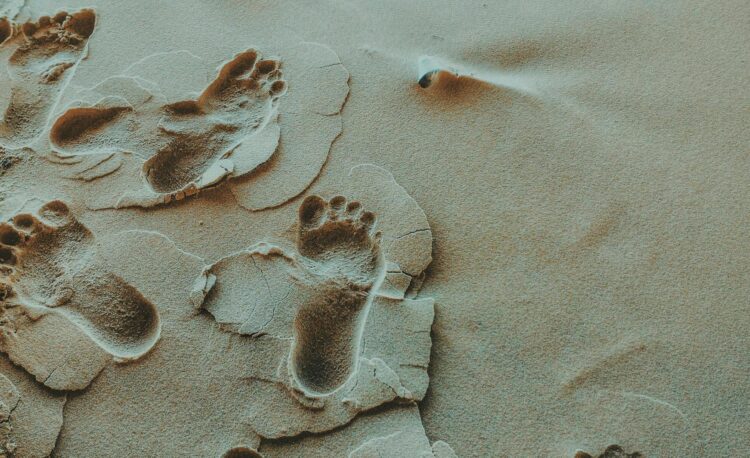 person foot prints on sands photo