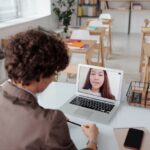 a teacher talking to her student using a laptop