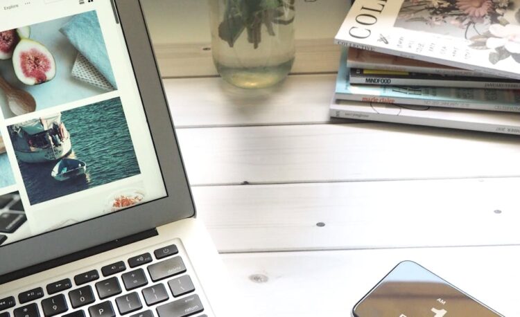 macbook air flower bouquet and magazines on white table